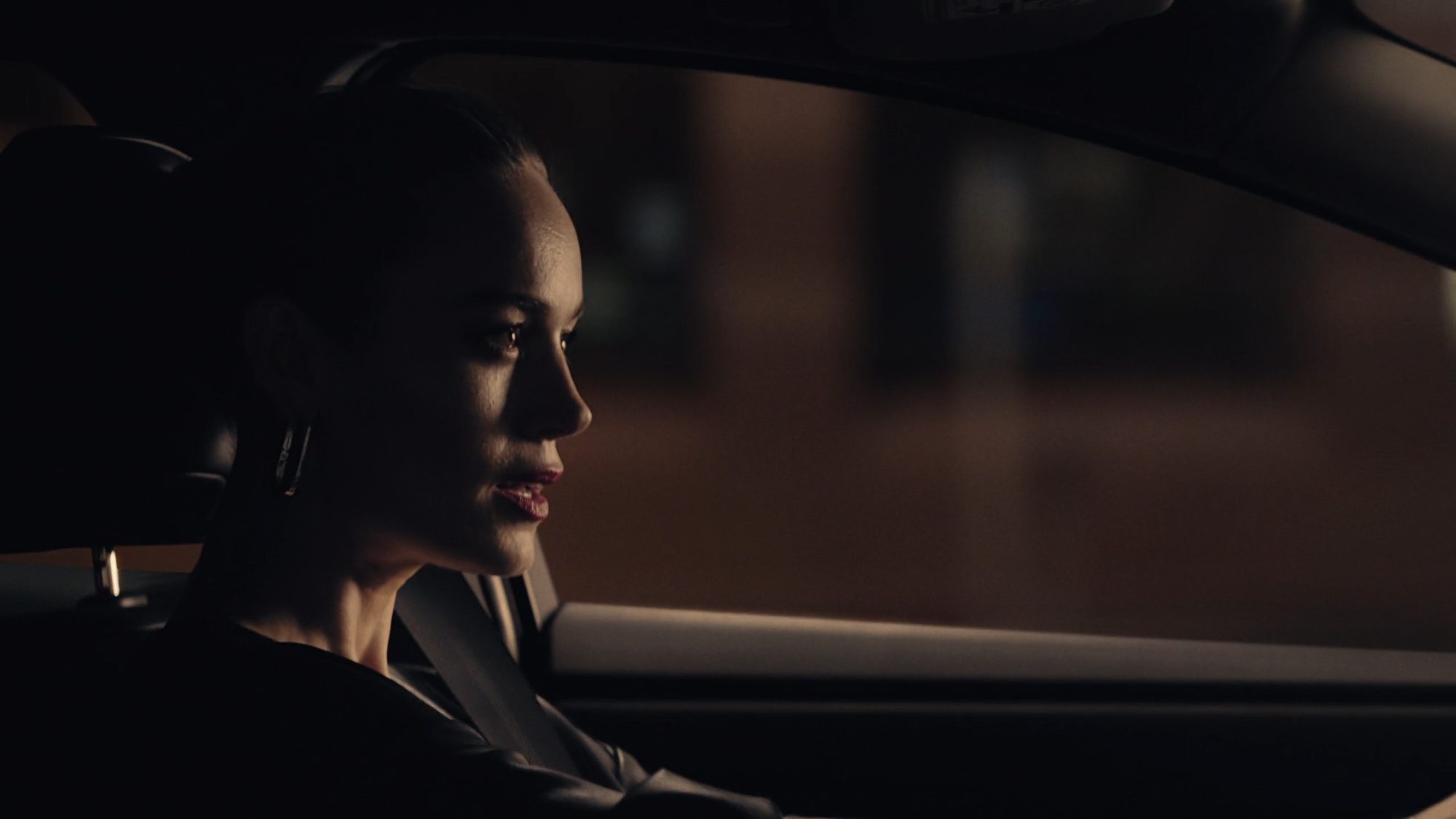 A woman driving at night in profile